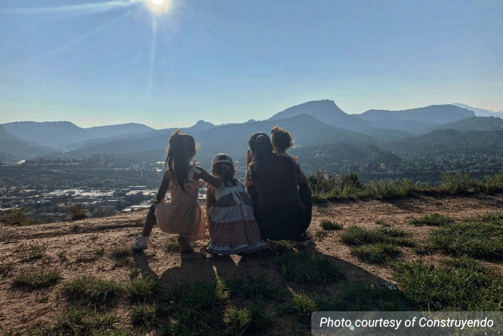 Photo of a women and three girls overlooking a mountain range. Courtesy of Construyendo