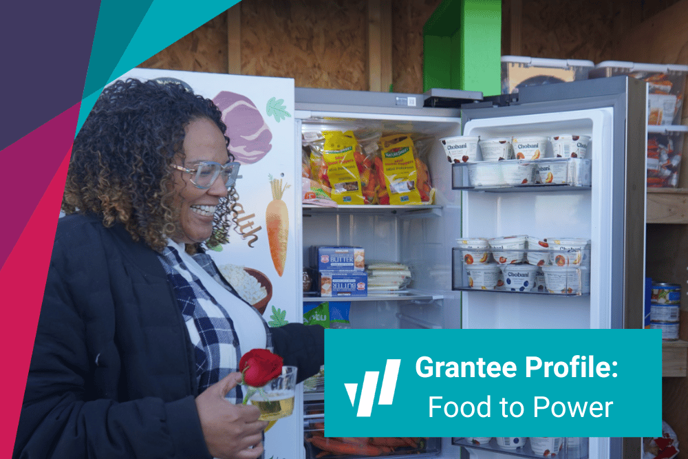 A woman stands in front of an open refrigerator stocked with healthy food
