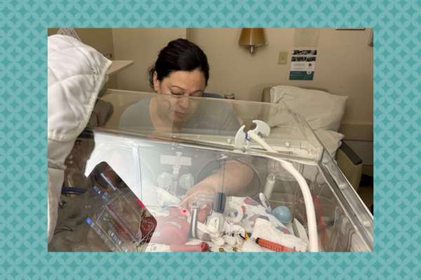 Farra sits next to baby Olivia in the NICU.