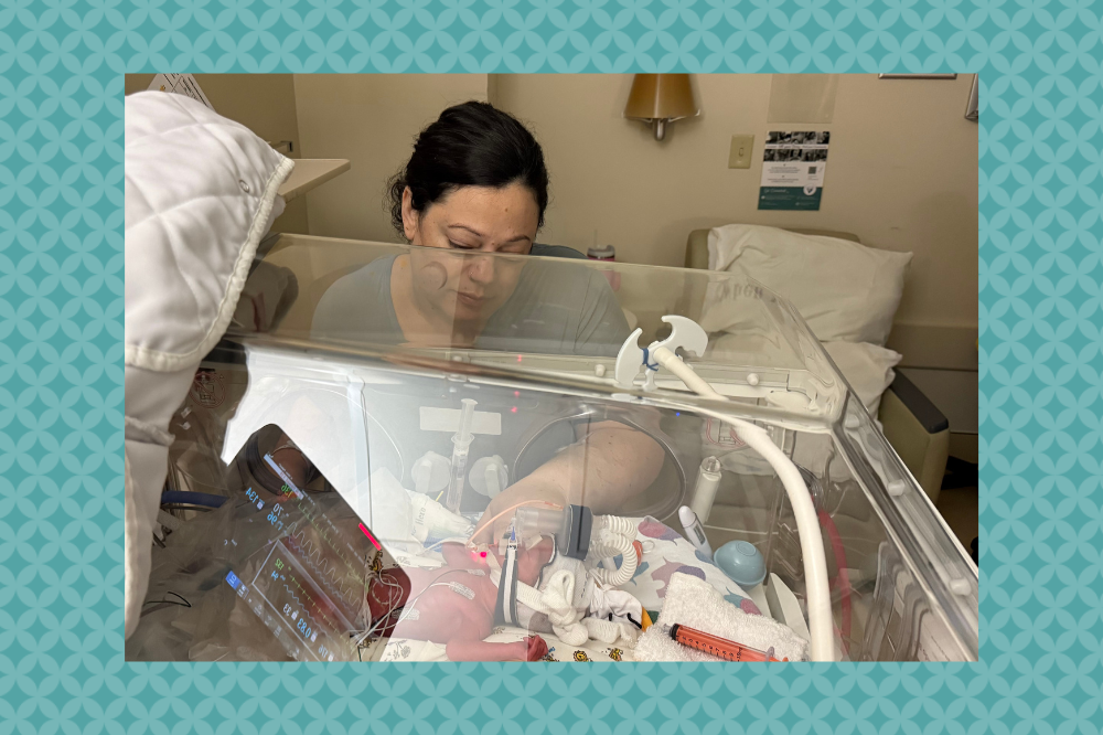 Farra sits next to baby Olivia in the NICU.