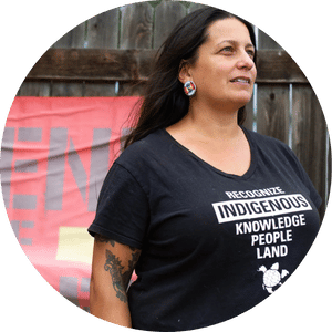 Headshot of Monycka Snowbird wearing a shirt that says "Recognize Indigenous Knowledge People Land" with a Turtle Island graphic