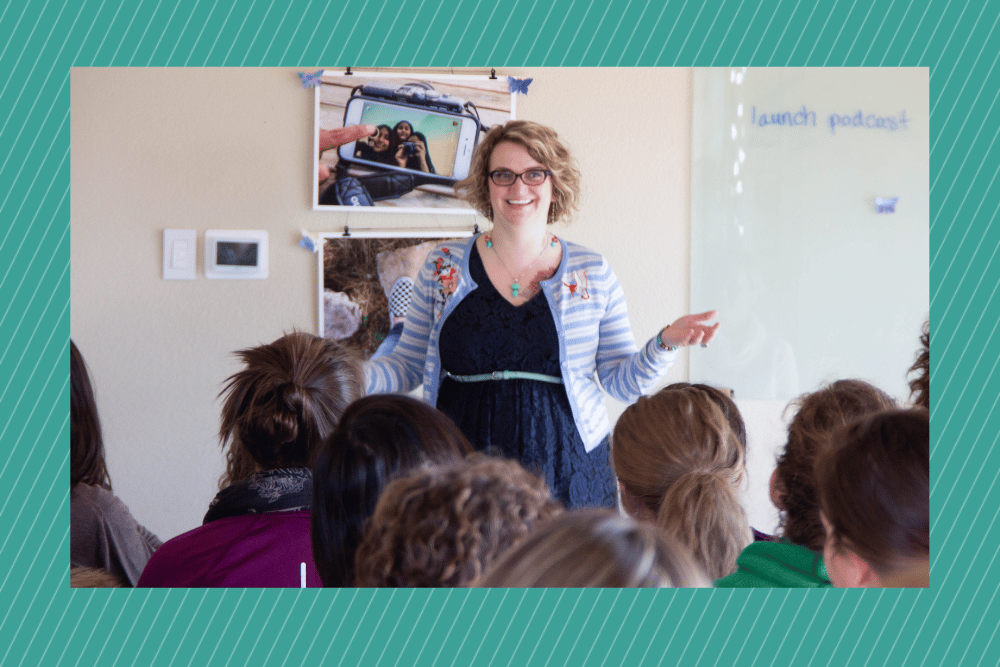 A white woman with glasses speaks to a group of people on overcoming imposter syndrome.