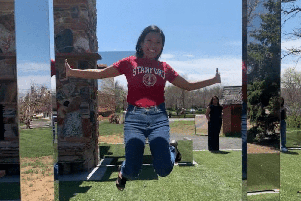 Woman jumping for joy wearing a Stanford shirt